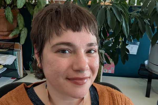 Photo of Anja Hogan at desk in front of houseplants