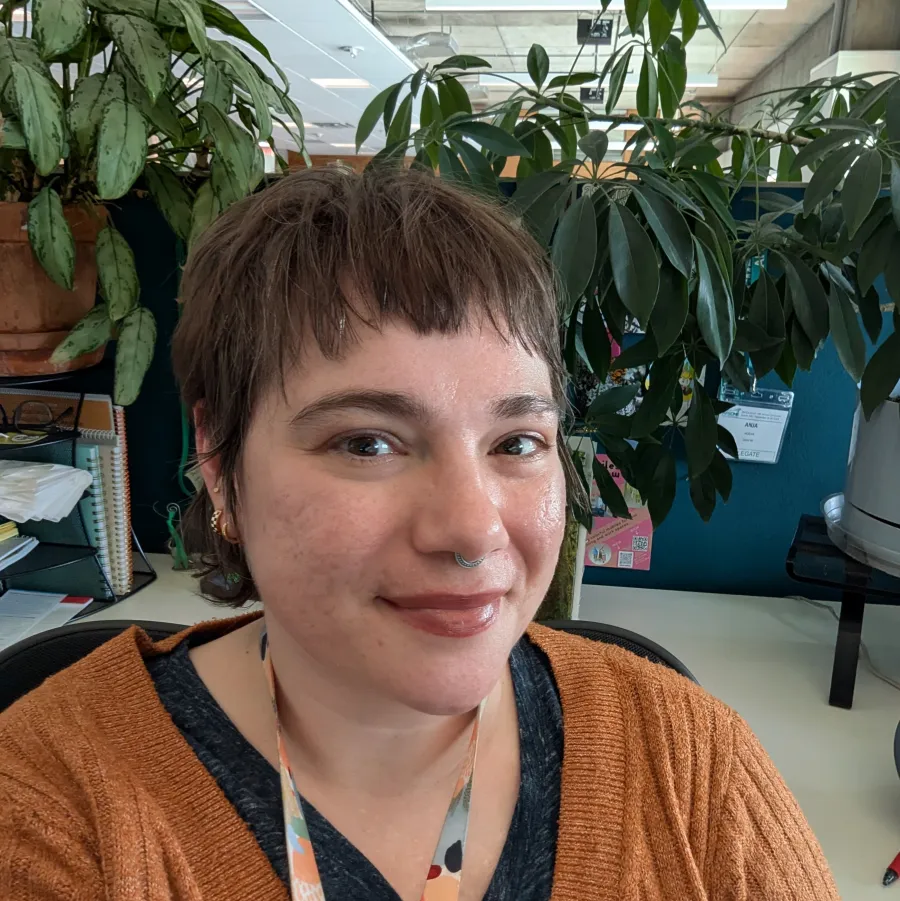 Photo of Anja Hogan at desk in front of houseplants