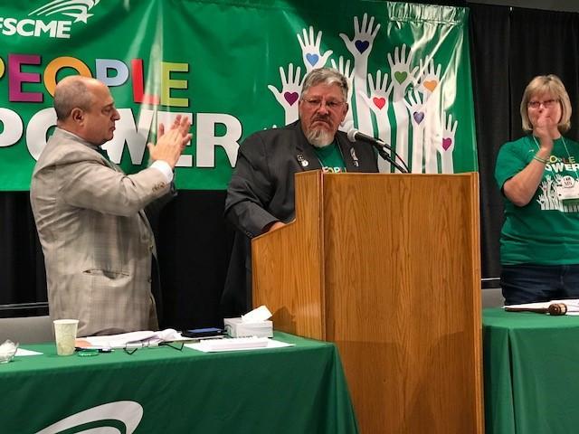 AFSCME Council 5 executive director Eliot Seide and president Judy Wahlberg applaud Council 61 president Danny Homan (center).